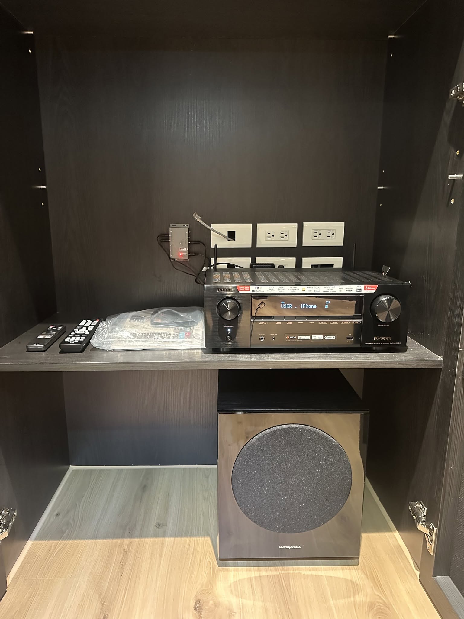 AV擴大機與重低音集中隱藏收納於櫃體內，層板分層與插座線材整理