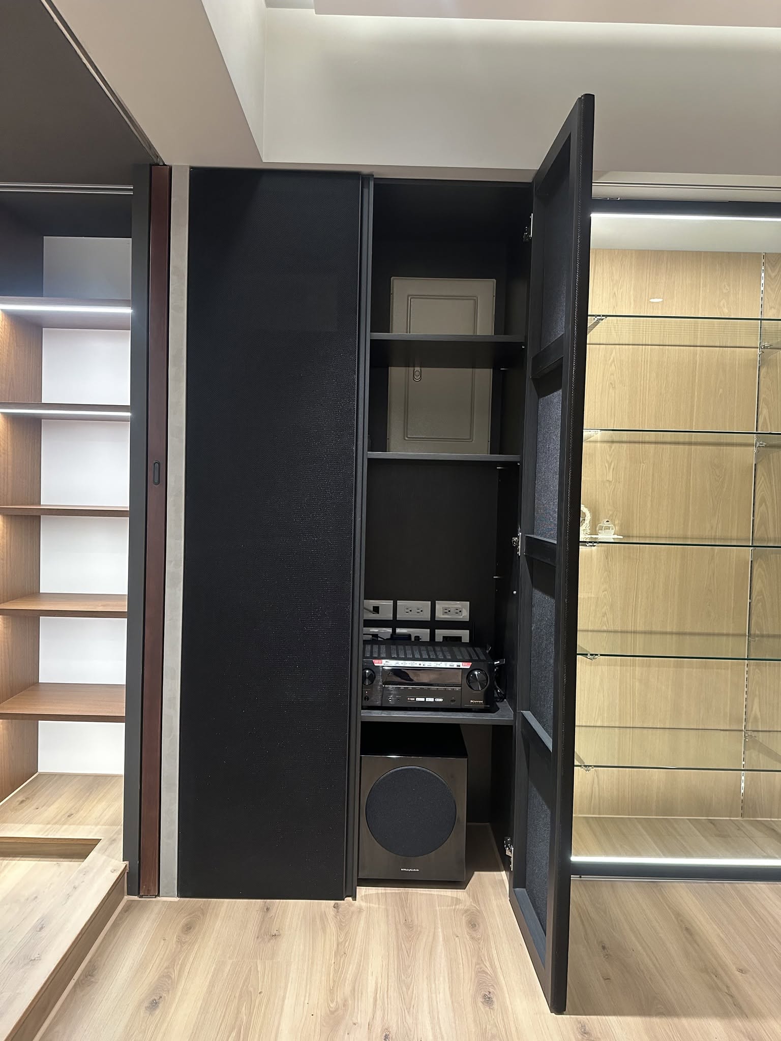 重低音與AV擴大機整合收納於櫃體內，透氣網罩門片打開內部樣貌